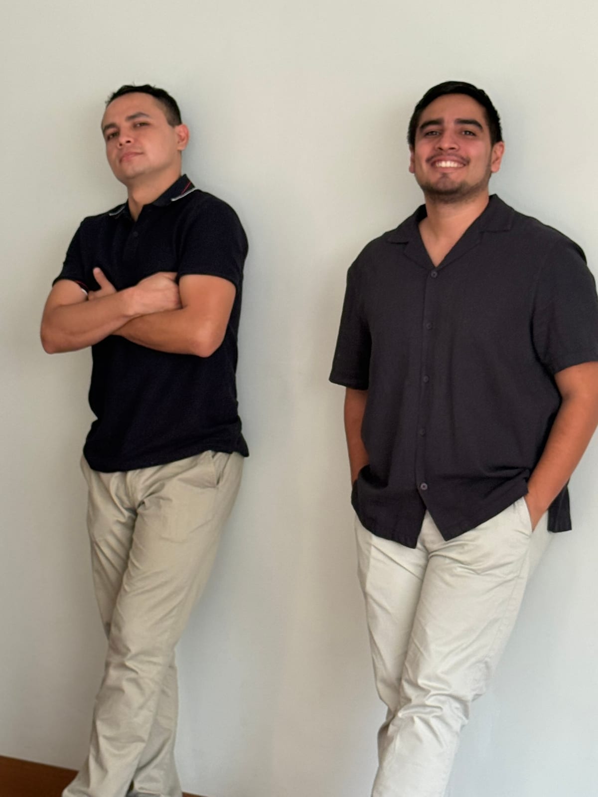 Dos integrantes del equipo de R'HOME posando frente a una pared blanca