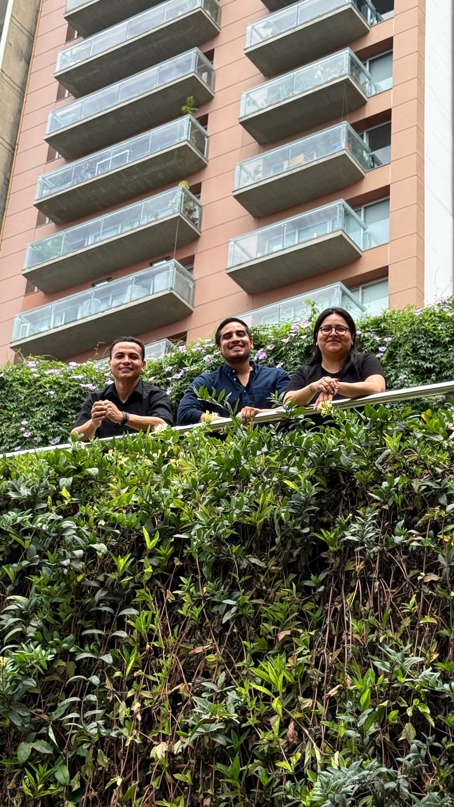 El equipo de R'HOME en la terraza ajardinada de un edificio residencial