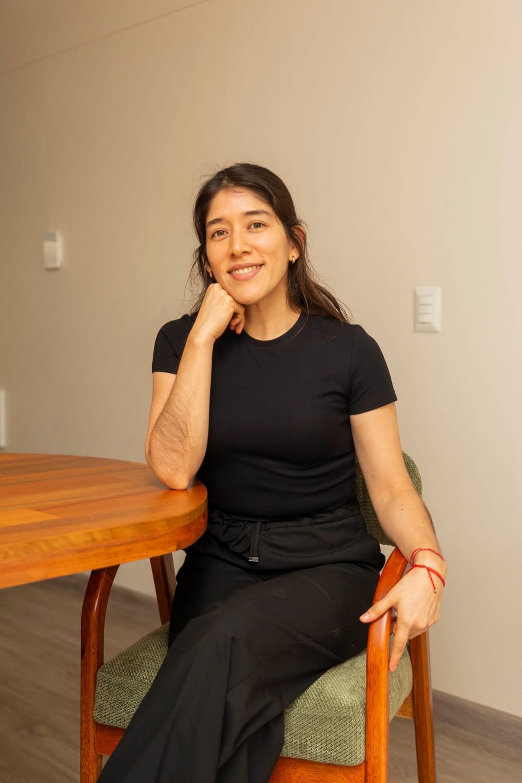 Carmen Rosa Pineda, de R'HOME, sentada junto a la mesa del comedor de un departamento