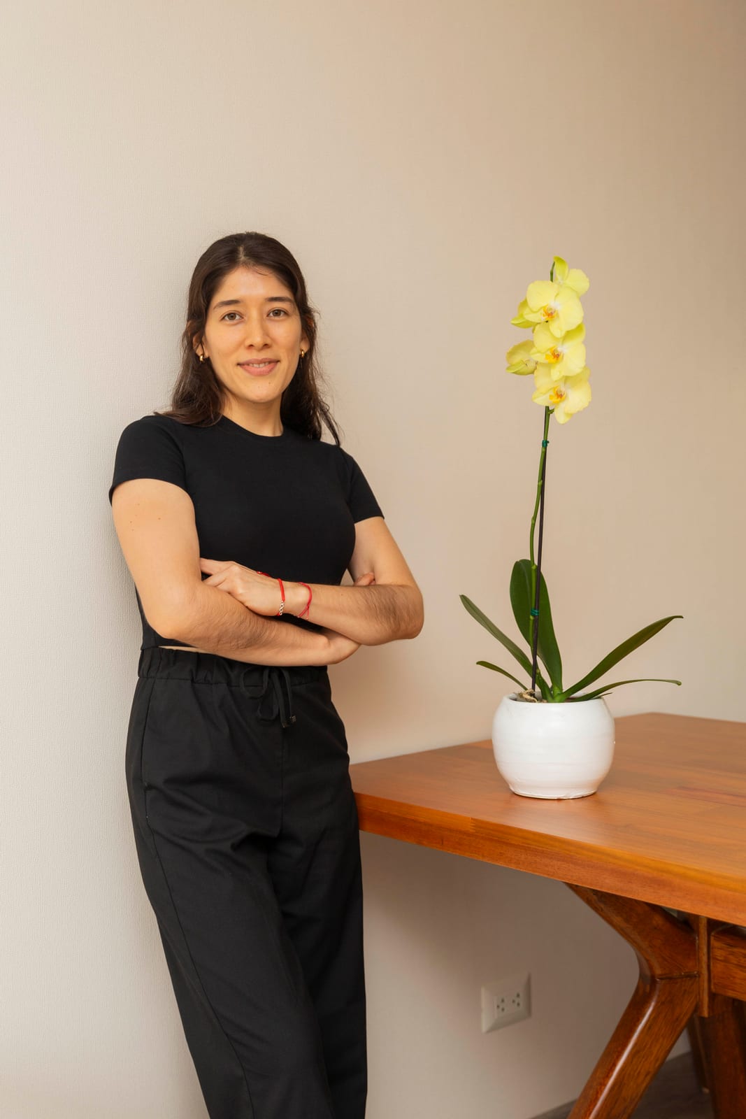 Carmen Rosa Pineda, de R'HOME, de pie junto a una mesa con una orquídea amarilla